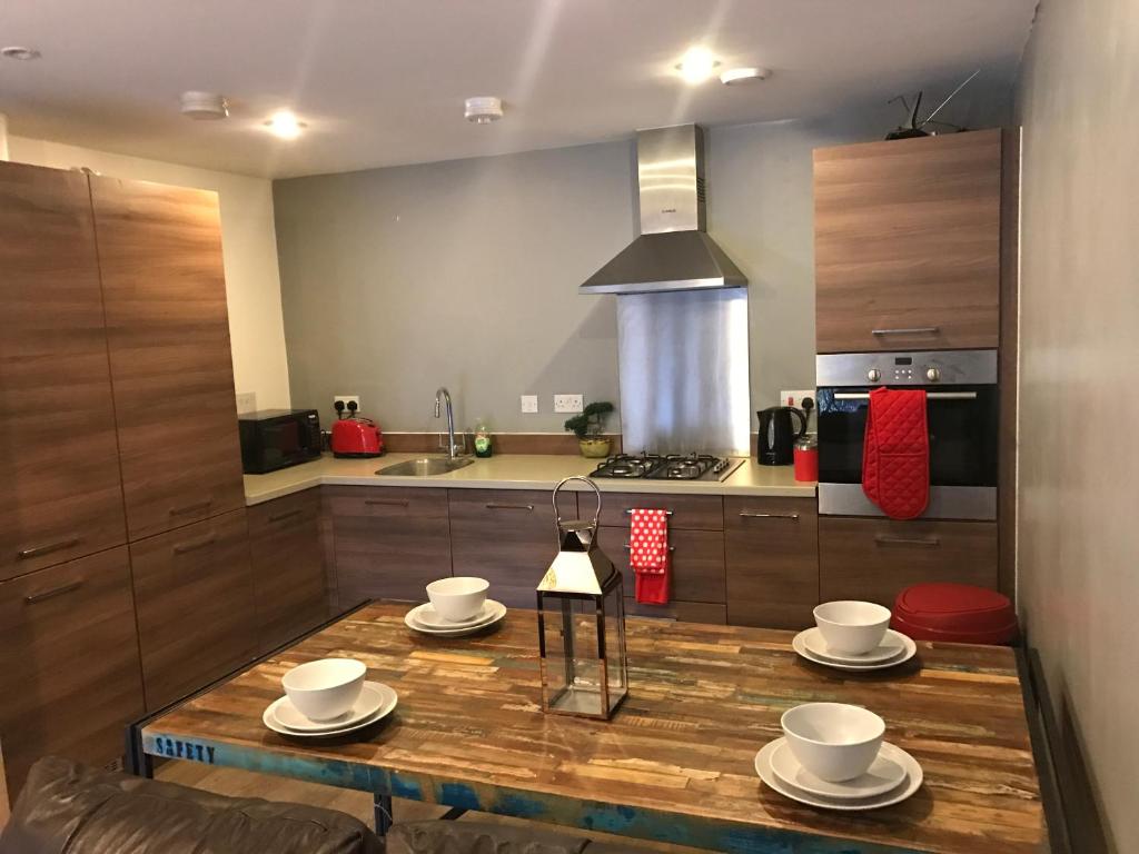 a kitchen with a wooden table with cups and saucers on it at Executive Brentwood Apartment in Brentwood