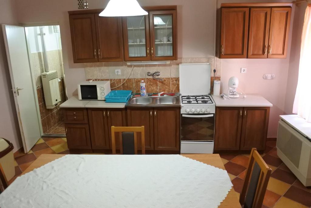 a kitchen with a sink and a stove top oven at Kisasszony apartman in Eger