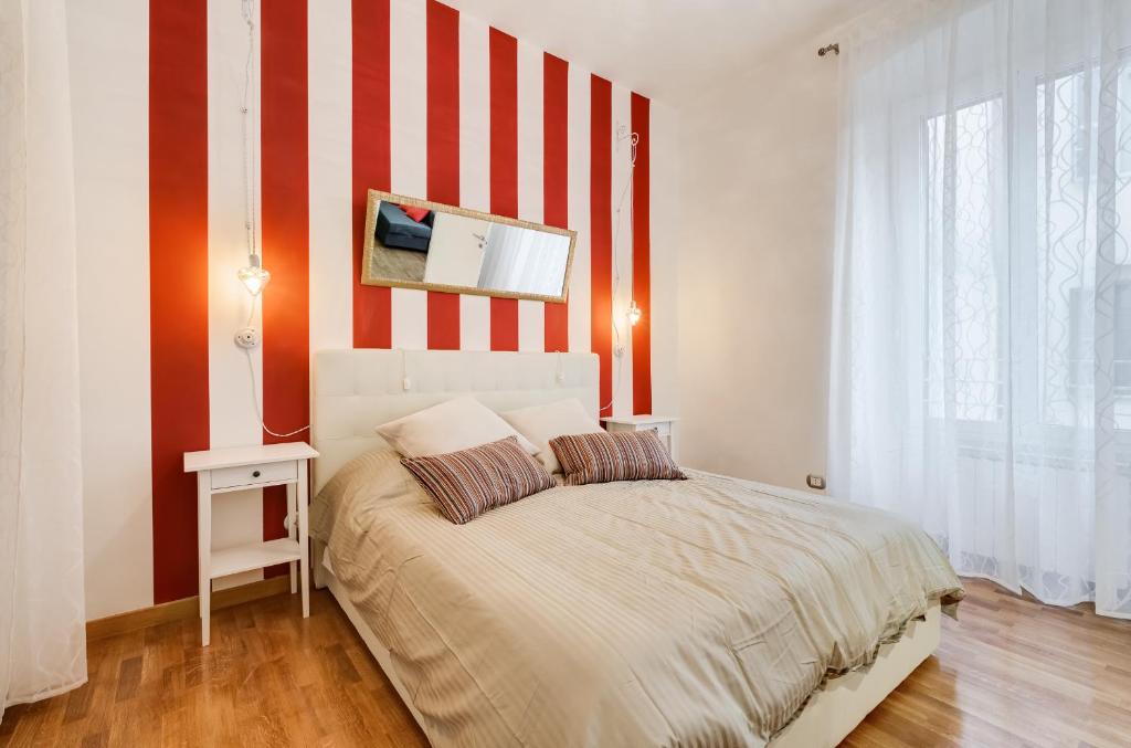 una camera con letto a righe rosse e bianche di San Cosimato House a Roma