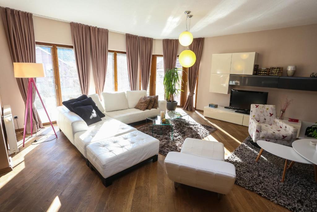 a living room with a white couch and chairs at Farah Superior Apartments in Bihać