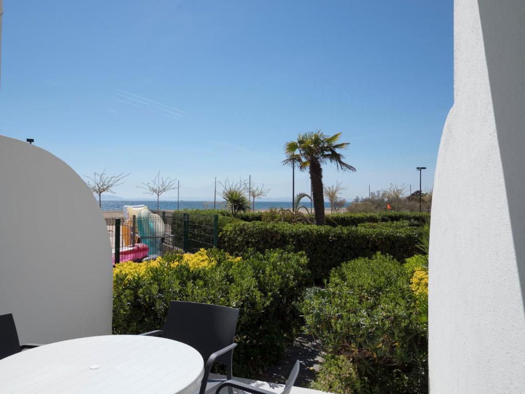 balcón con mesa, sillas y vistas al océano en InmoSantos Oasis E2, en Roses