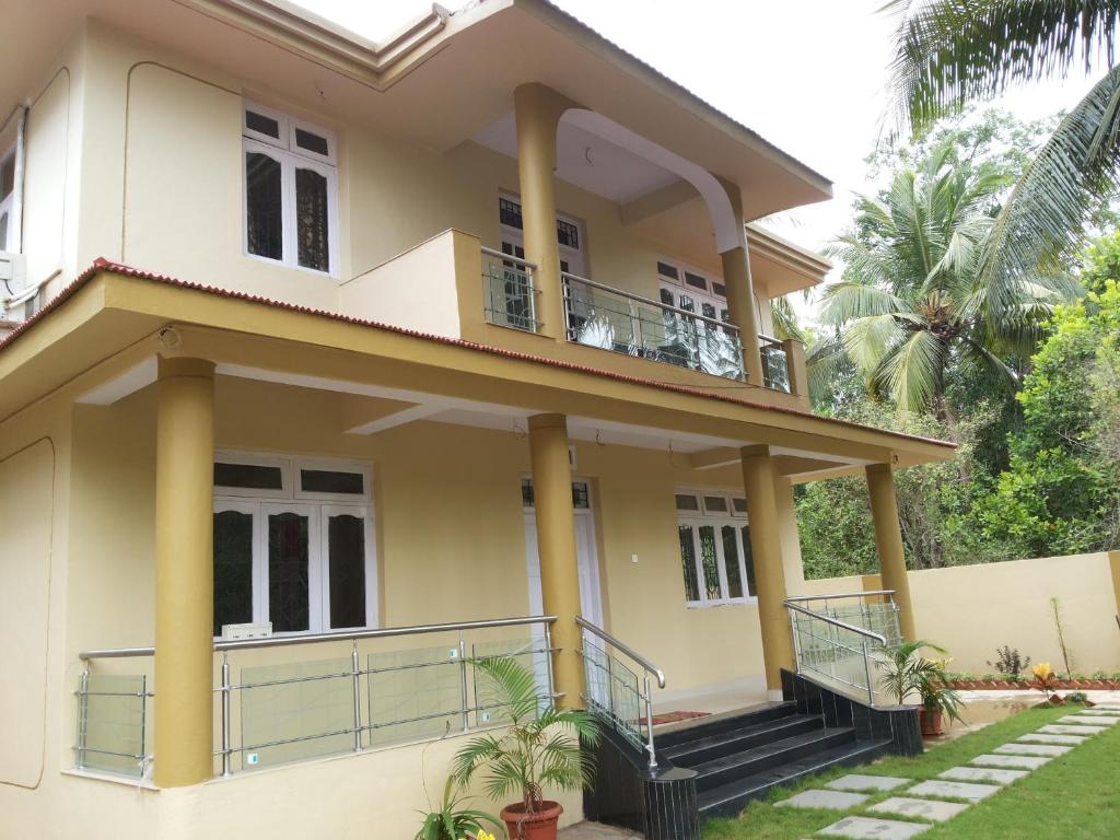 a house with a balcony in front of it at Guesthouse Sakina Colva in Colva