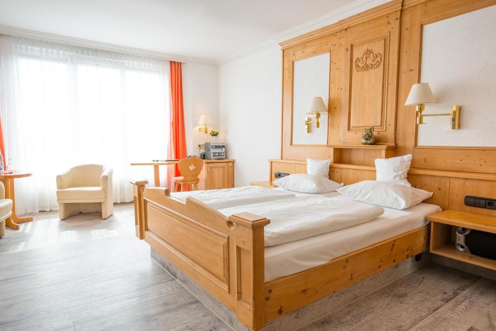 a bedroom with a large wooden bed in a room at AAAA Hotelwelt KÜBLER in Karlsruhe