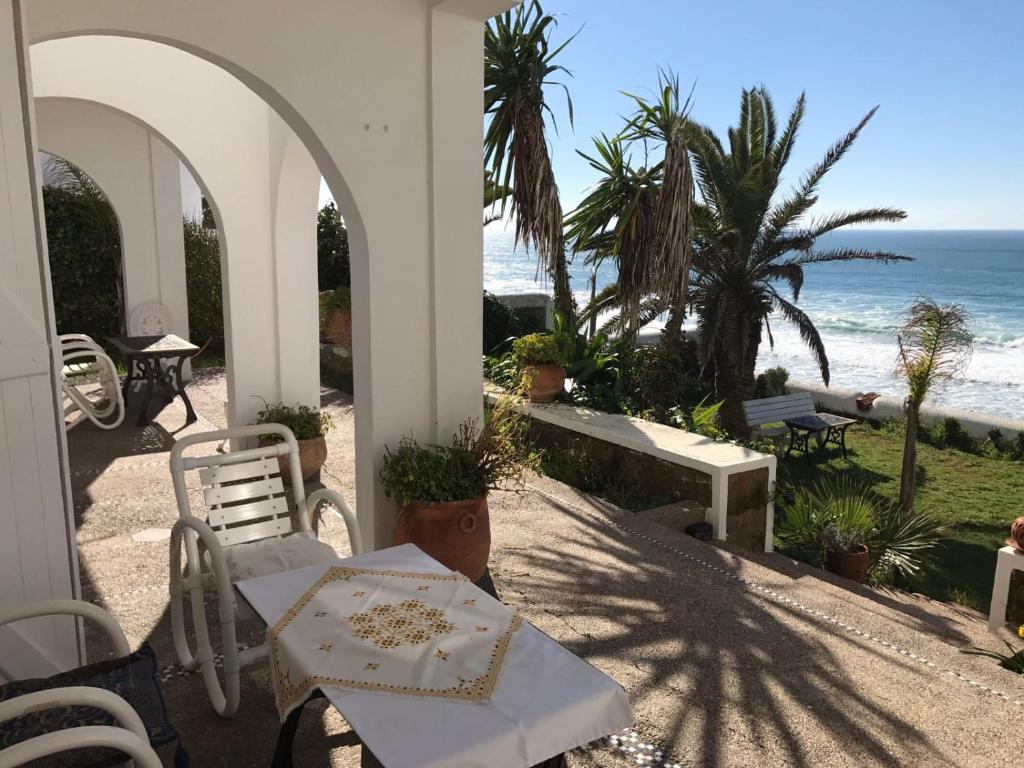 un patio con mesa y sillas y la playa en Villa Nora, en Moulay Bousselham