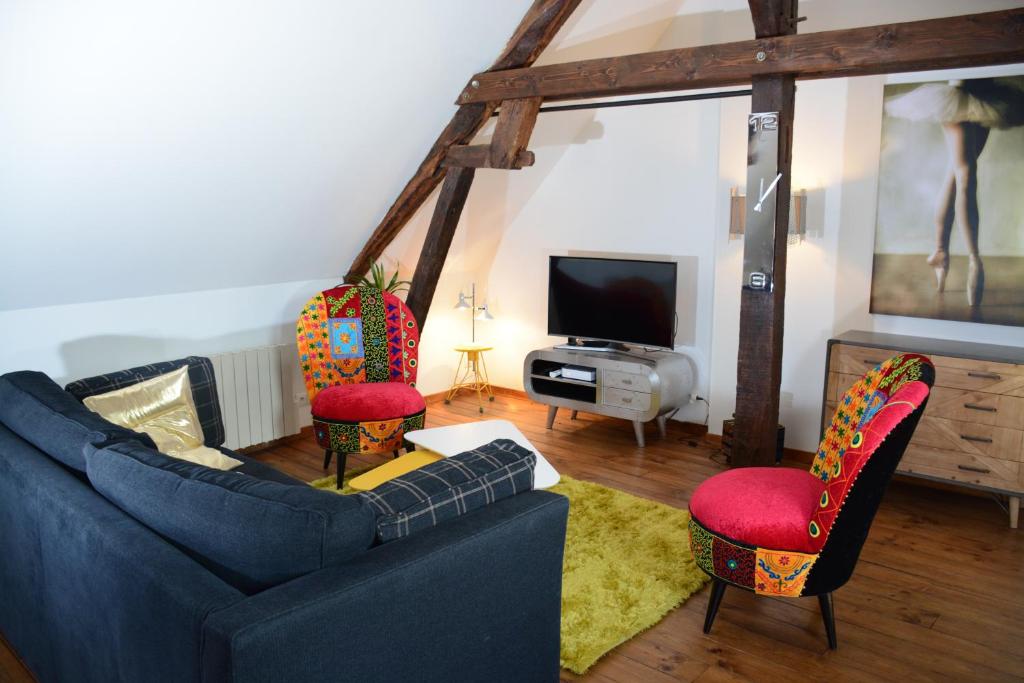 sala de estar con sofá azul y 2 sillas en Loft en bulles, en Épernay