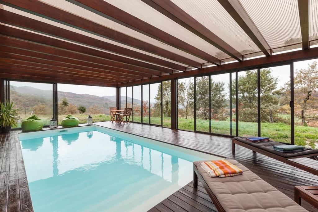 a swimming pool with a view of a house at Casa dos Colados in Fafe