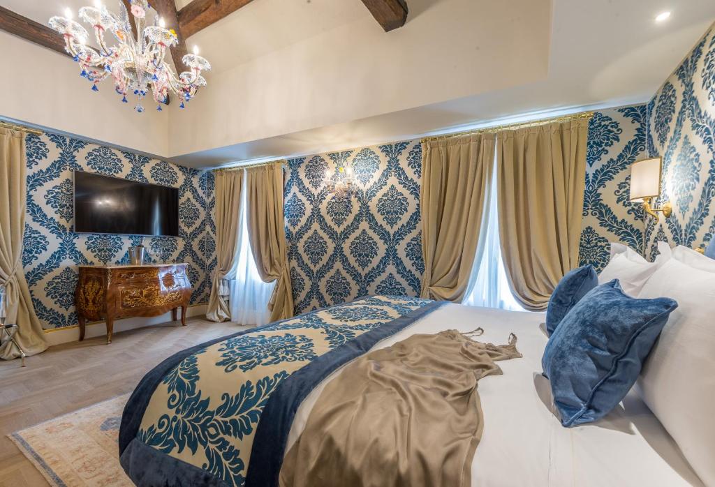 a bedroom with a bed and a chandelier at Ai Patrizi di Venezia in Venice