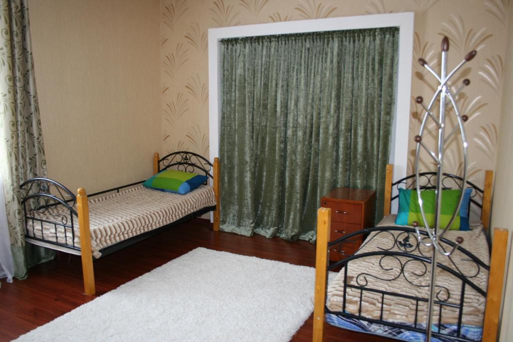 a bedroom with two beds and a window at Hostel Americana in Astana