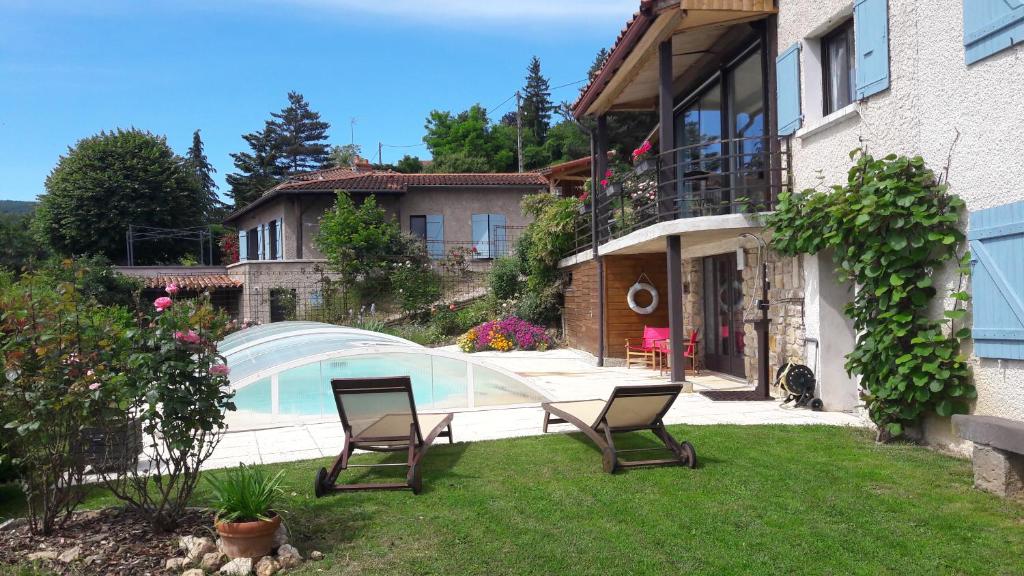 a yard with two chairs and a swimming pool at Clair Matin in Villeneuve-dʼAllier