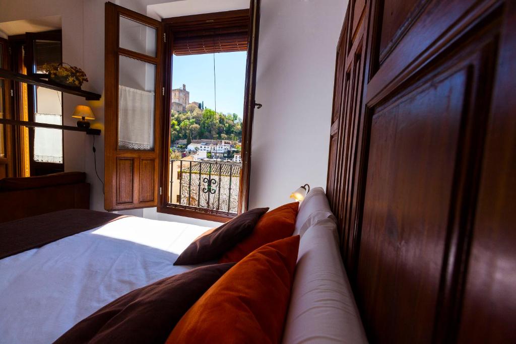 a bedroom with a bed and a large window at Casa del Cantaor in Granada