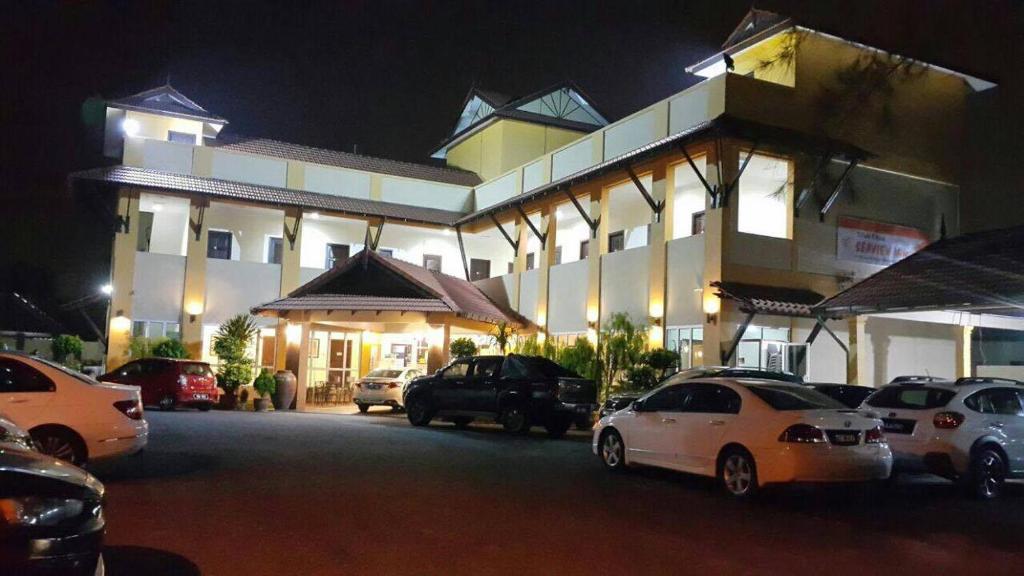 a building with cars parked in front of it at night at Teluk Lipat Seaview Inn in Dungun