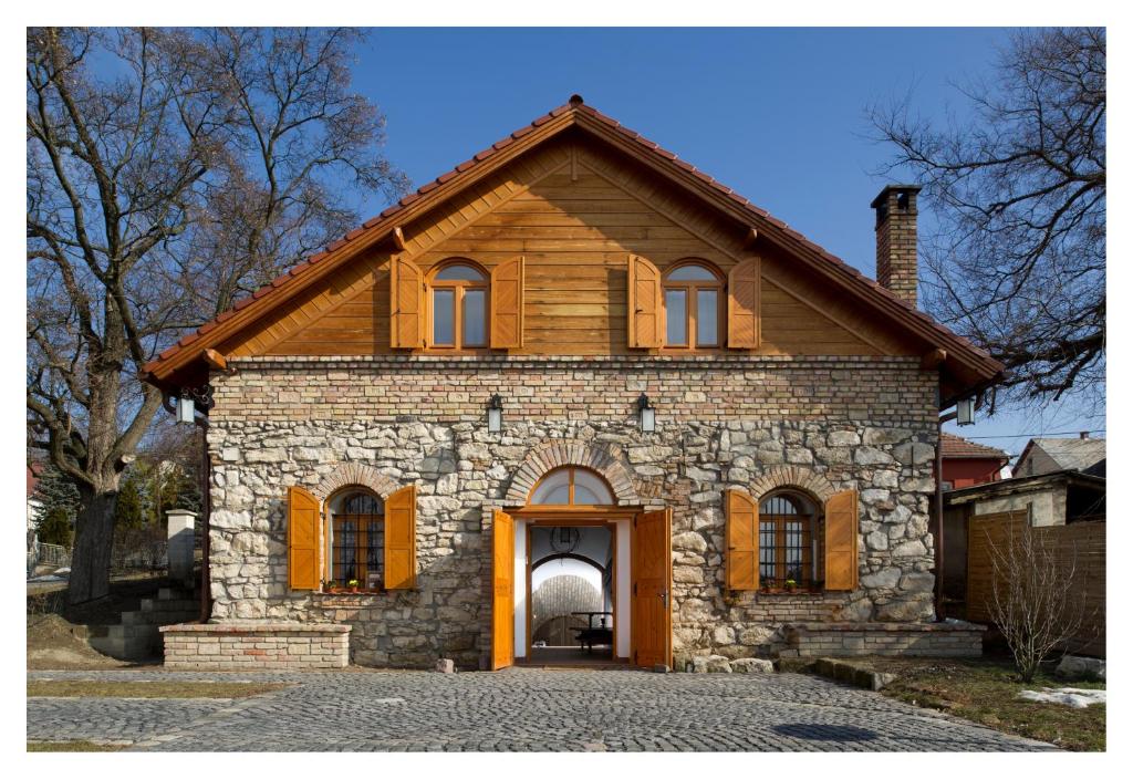 una vieja casa de piedra con una gran puerta. en Cifrapince és Vendégház, en Tordas