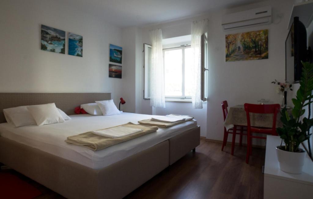 a bedroom with a white bed with towels on it at Gravosa Studios in Dubrovnik