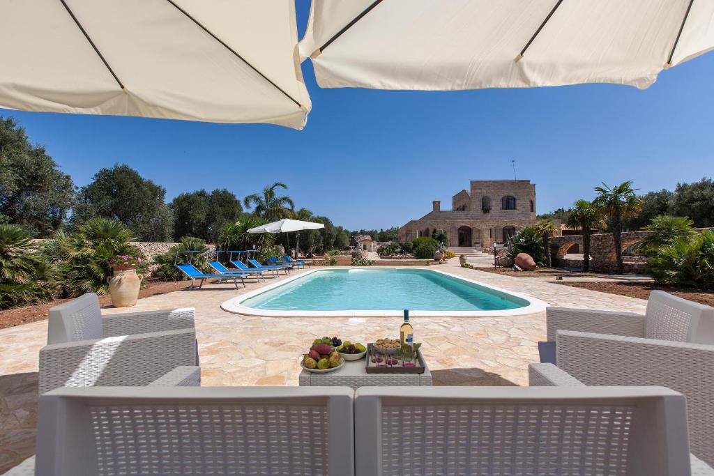 uitzicht op een zwembad met stoelen en een tafel bij Casale Tre Petre by BarbarHouse in Santa Maria al Bagno