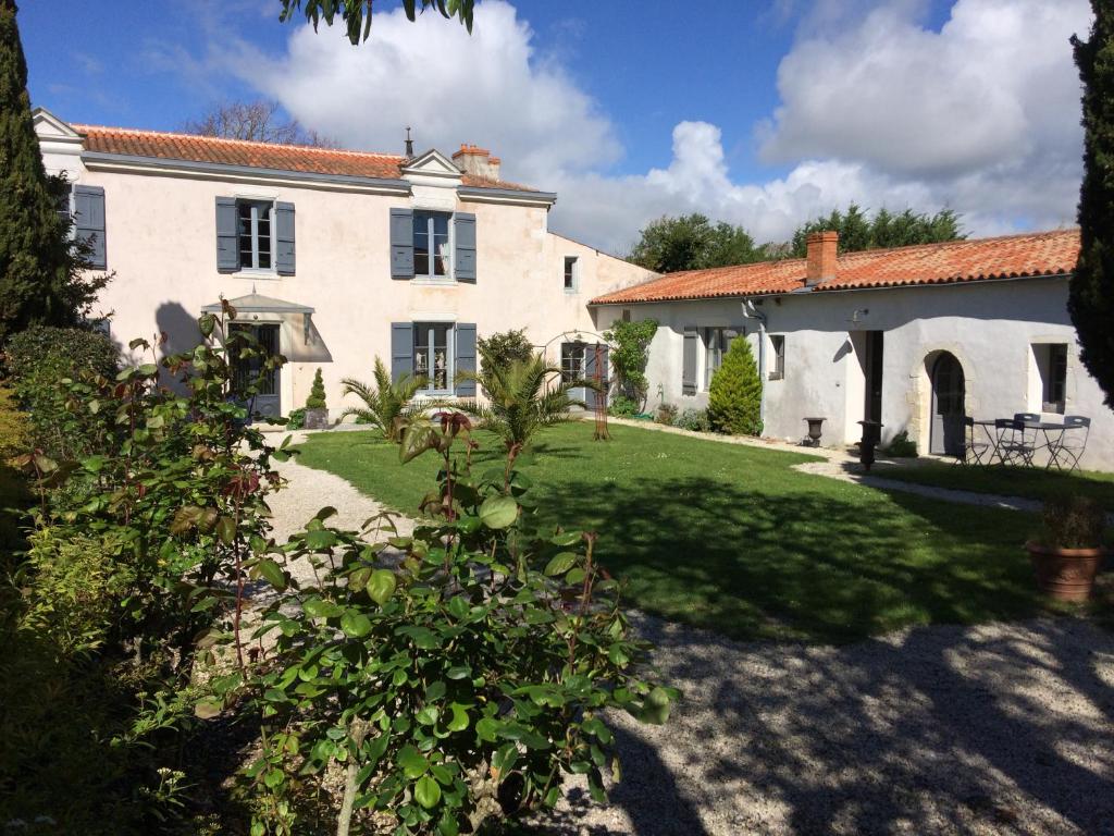 una grande casa bianca con cortile di La Rochelle L'ile de Ré Autrement a Nieul-sur-Mer