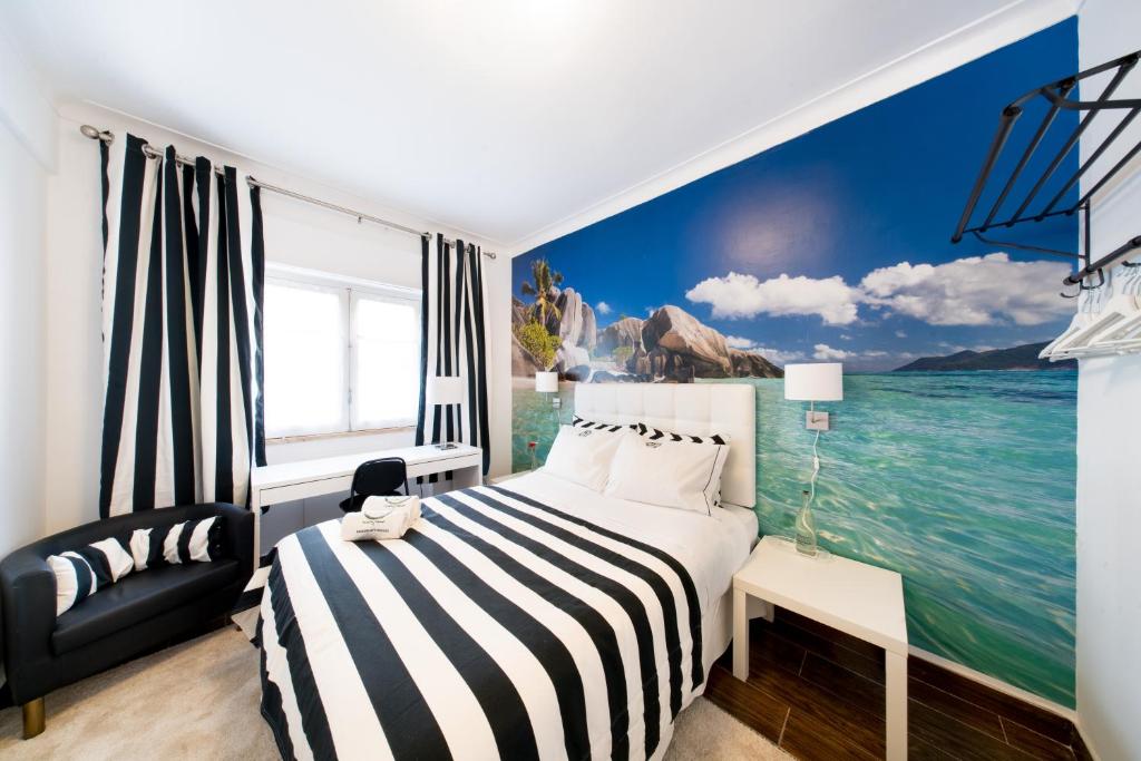 um quarto com uma cama e uma pintura do oceano em PH in Setúbal em Setúbal