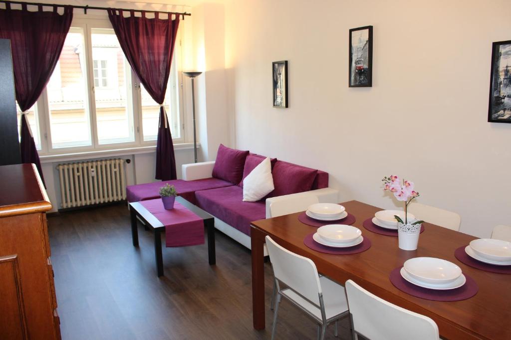 a living room with a purple couch and a table at Go Native Prague Apartment in Prague