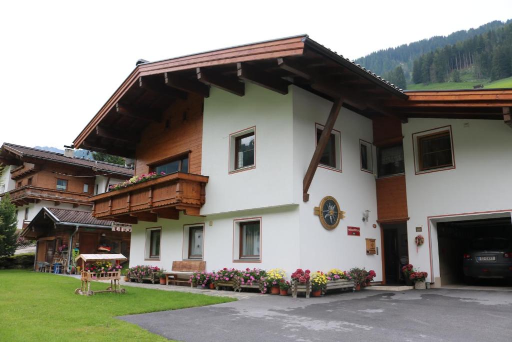 ein Gebäude mit einem Balkon und Blumen davor in der Unterkunft Ferienwohnung Tomann in Tux