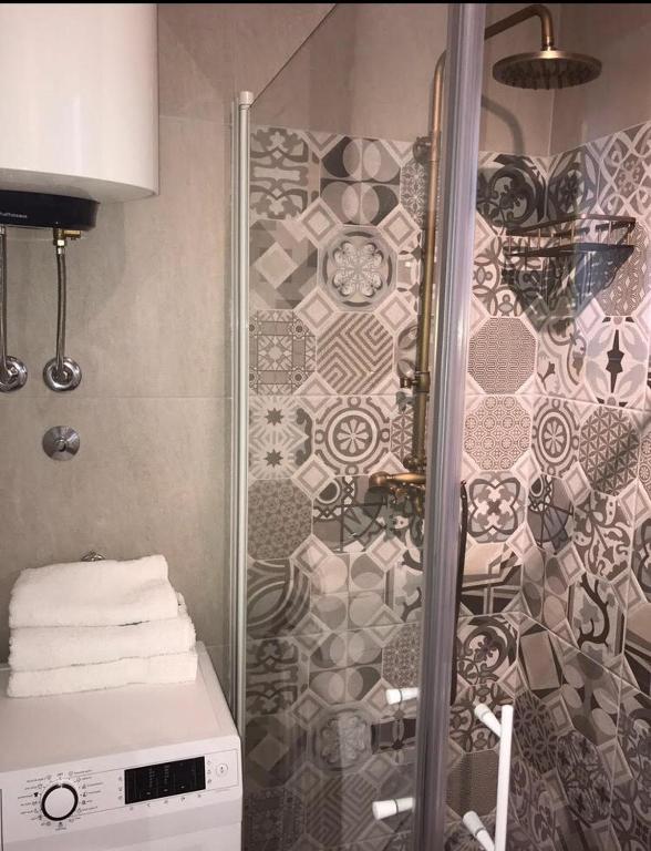 um chuveiro numa casa de banho com uma parede em mosaico em Apartment Ria em Split