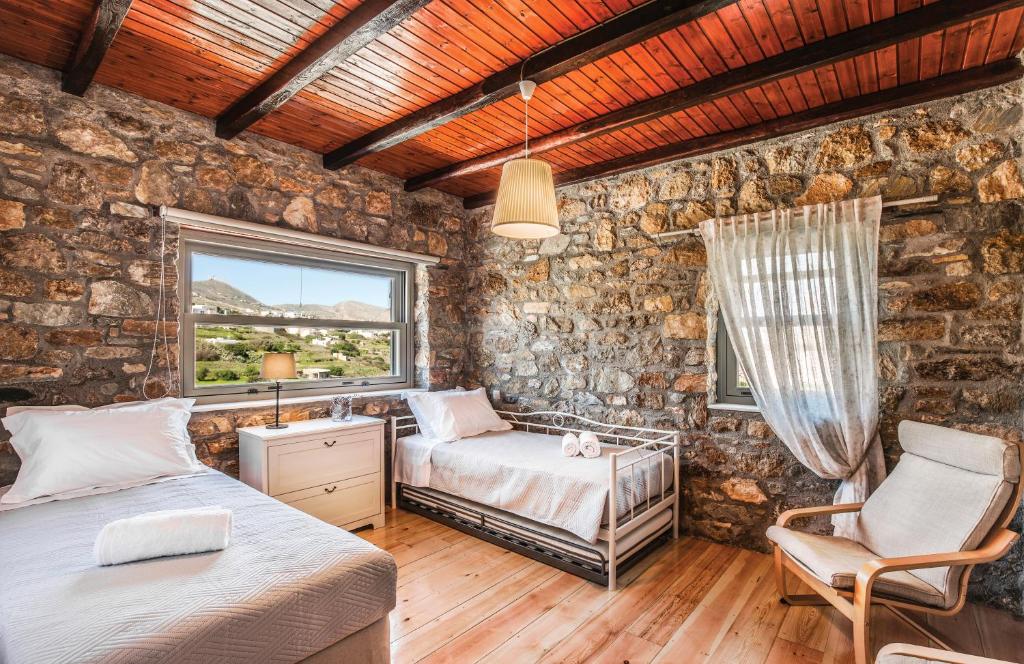 una camera con due letti e una finestra di Avrofilito Syros Houses a Ermoupoli