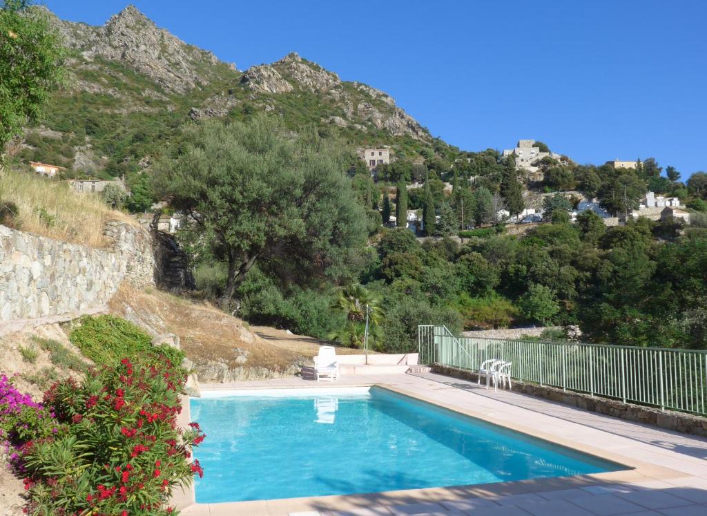 a swimming pool with a mountain in the background at petit paradis pres ile rousse gîte les cortalines Lama in Lama