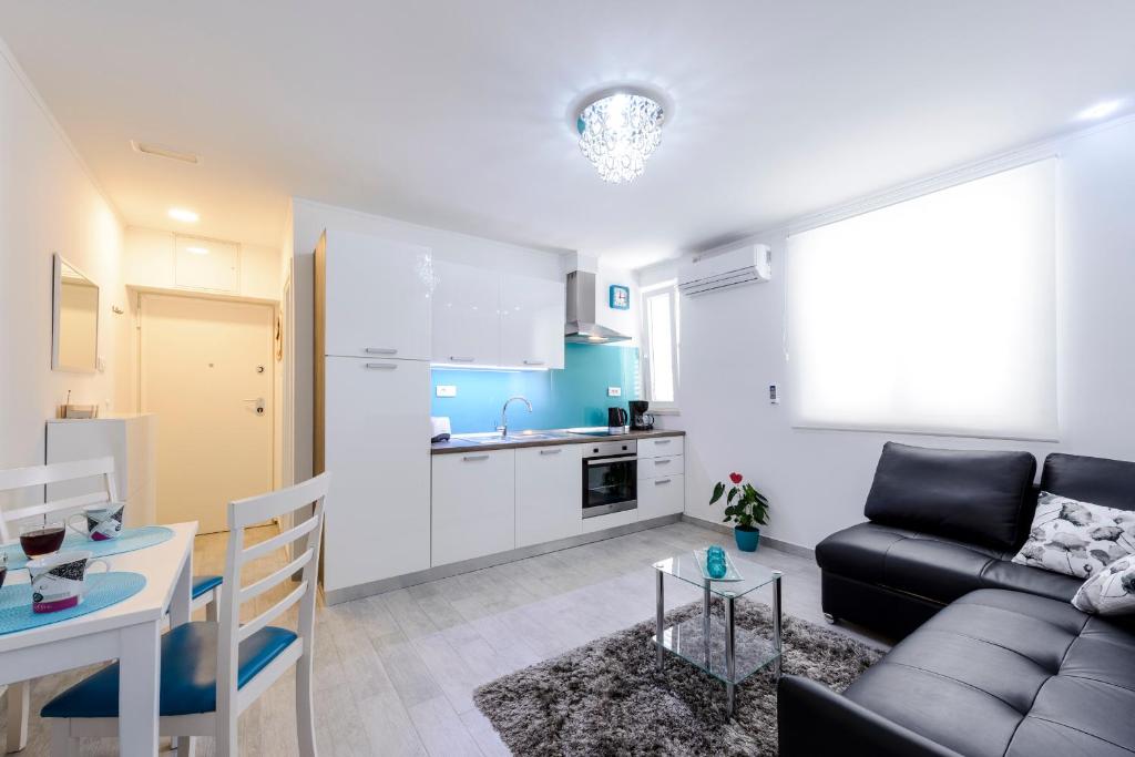 uma sala de estar e cozinha com um sofá e uma mesa em Apartment Andrea 1 em Dubrovnik