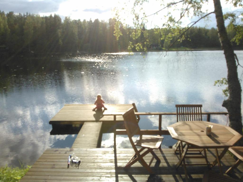 een kind op een steiger boven een meer bij Lohja Chalet at Lake Enäjärvi in Karjalohja