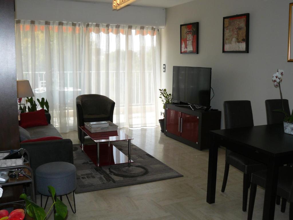 un salon avec une télévision et une table dans l'établissement Parouquine, à Antibes