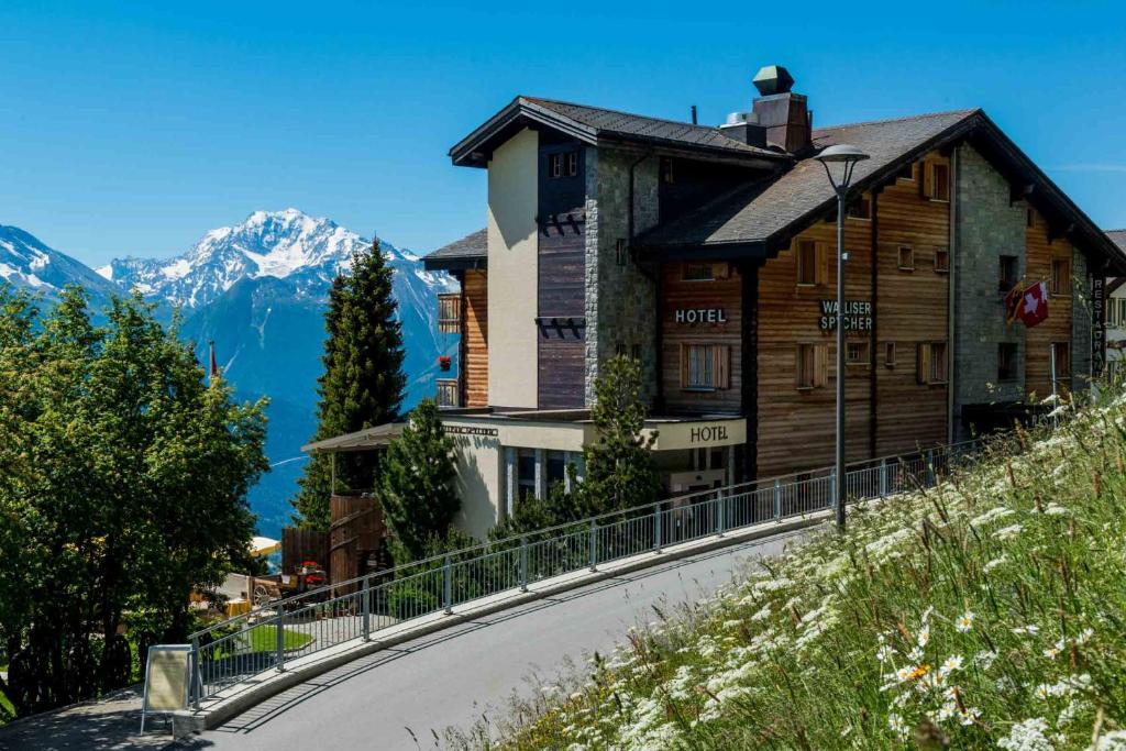 a building on the side of a road with a mountain at Swiss Chalet-Style Hotel Walliser Spycher in Riederalp