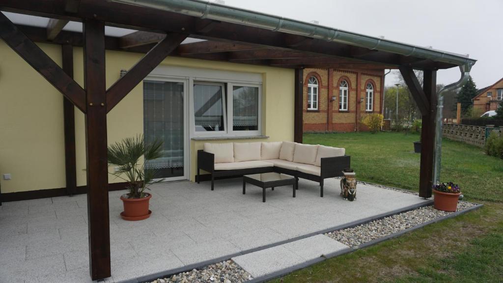 a covered patio with a couch and a table at Ferienwohnung Kaiser Lübben in Lübben