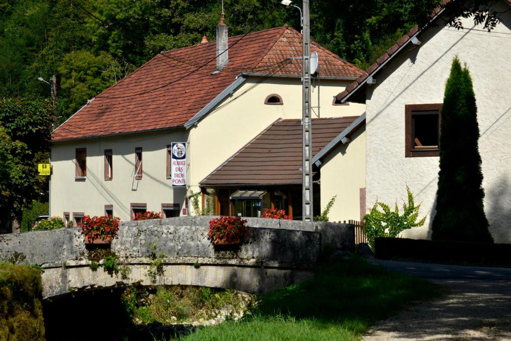 a house with a bridge in front of it at L'auberge Des 3 Ponts in Cusance