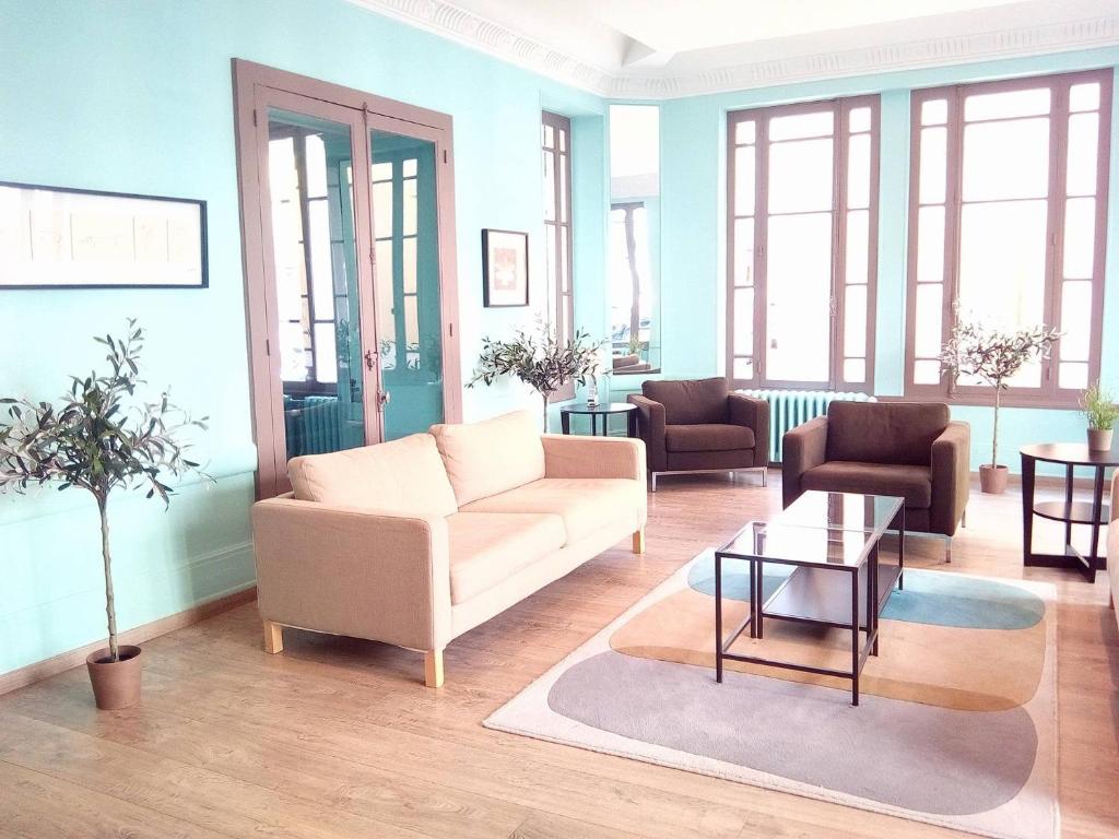 ein Wohnzimmer mit einem Sofa und einem Tisch in der Unterkunft Vichy Résidencia in Vichy