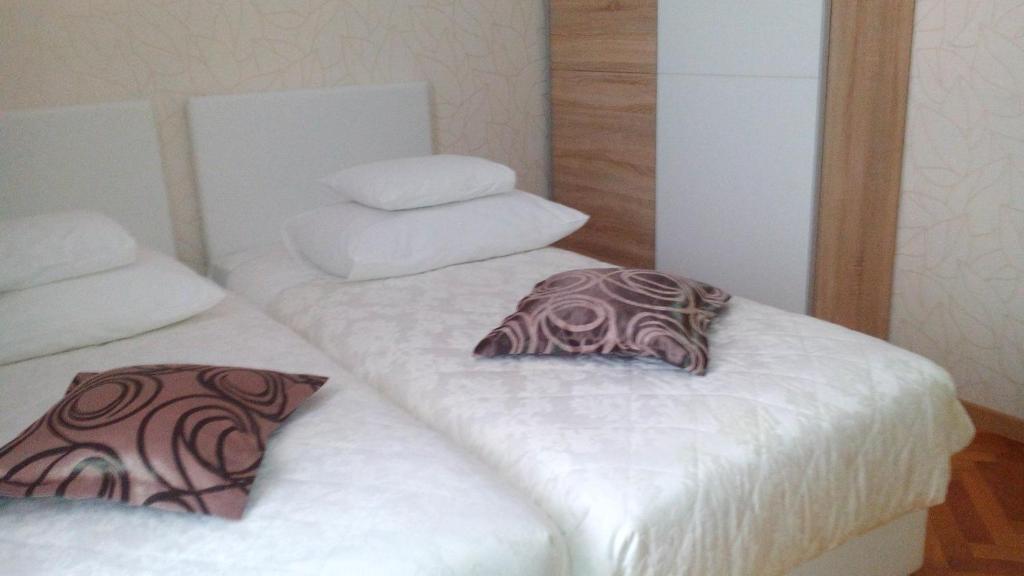 two beds with white sheets and a pillow on them at Guesthouse Vrlic in Split
