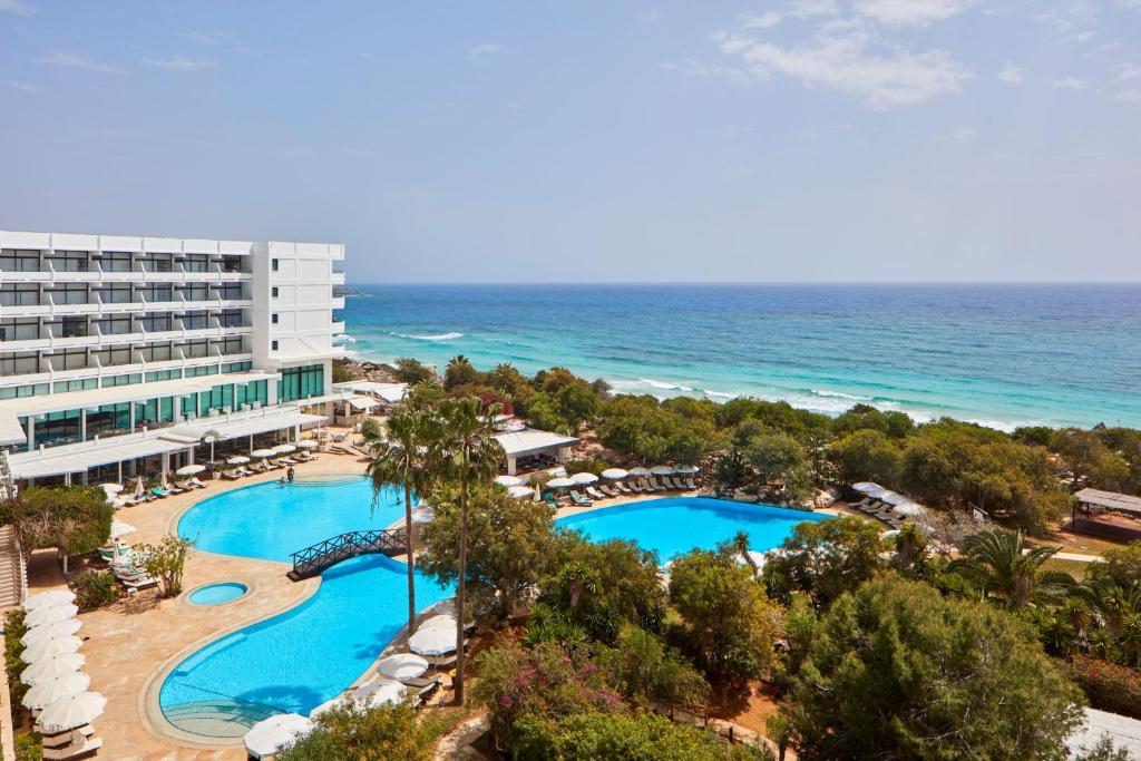 een luchtzicht op een resort met een zwembad en de oceaan bij Grecian Bay in Ayia Napa