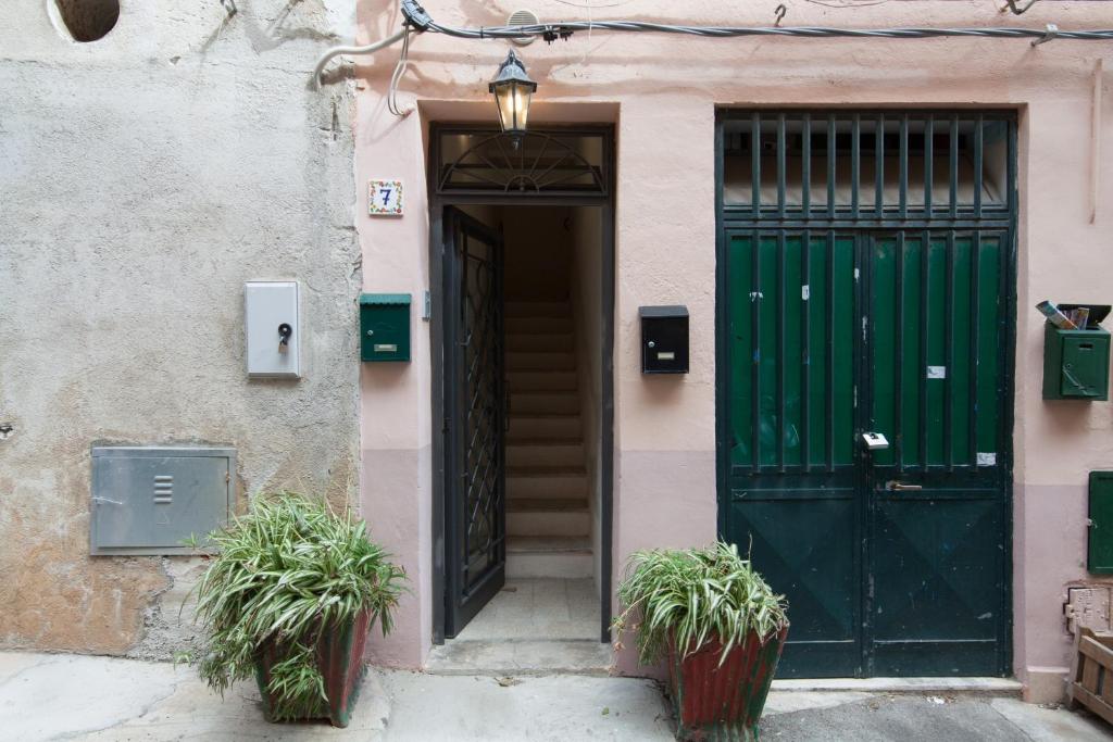 モンデッロにあるHoliday & House - Imparato Vacanze Prestige Mondelloの鉢植え二本の建物の緑の扉