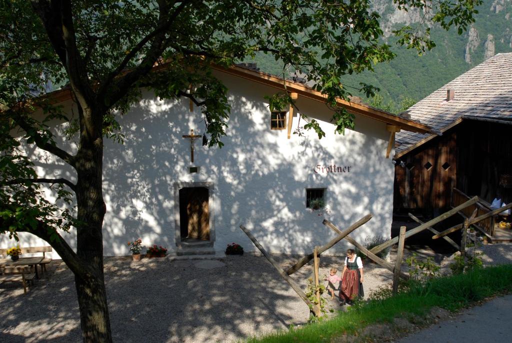 uma igreja branca com uma cruz ao lado em Grottnerhof em Fiè