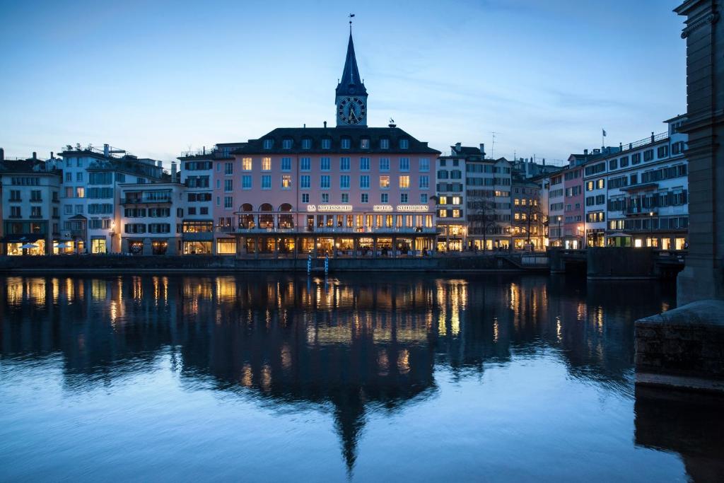 蘇黎世的住宿－Storchen Zürich - Lifestyle boutique Hotel，一座有建筑的城市,晚上有河流