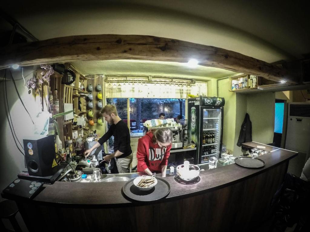 un hombre y una mujer preparando comida en una cocina en Arka Hostel, en Shkodër