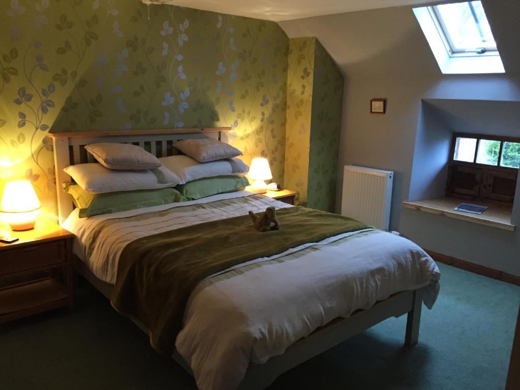 a bedroom with a bed with a cat sitting on it at Lodge at Lochside in Bridgend of Lintrathen