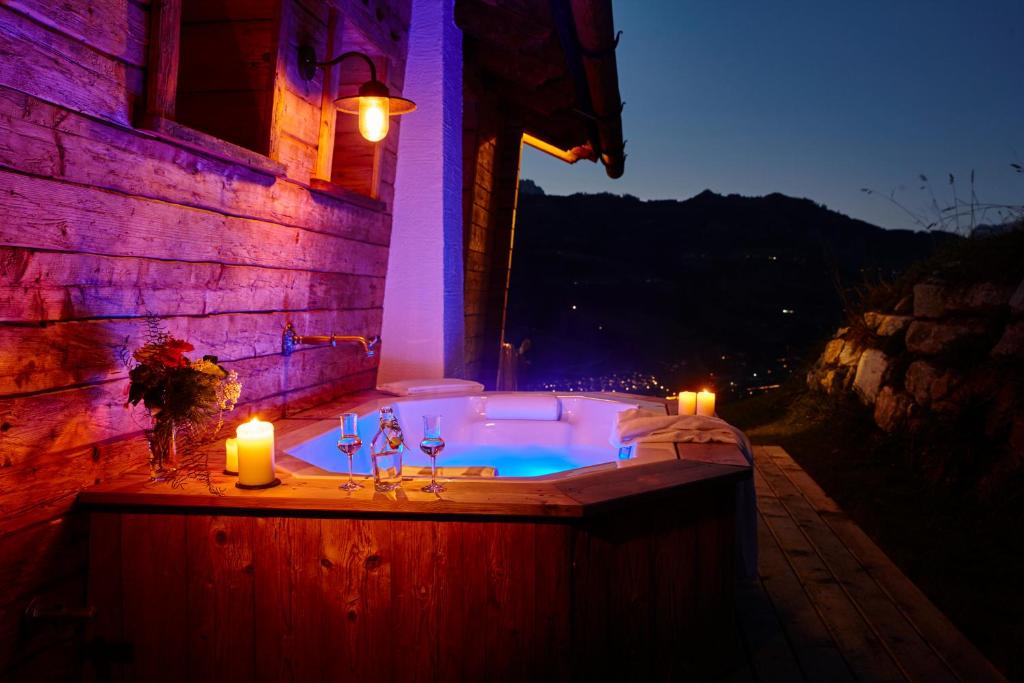 a jacuzzi tub with two candles and two candles at Chaletdorf BERGHERZ in Sankt Johann im Pongau