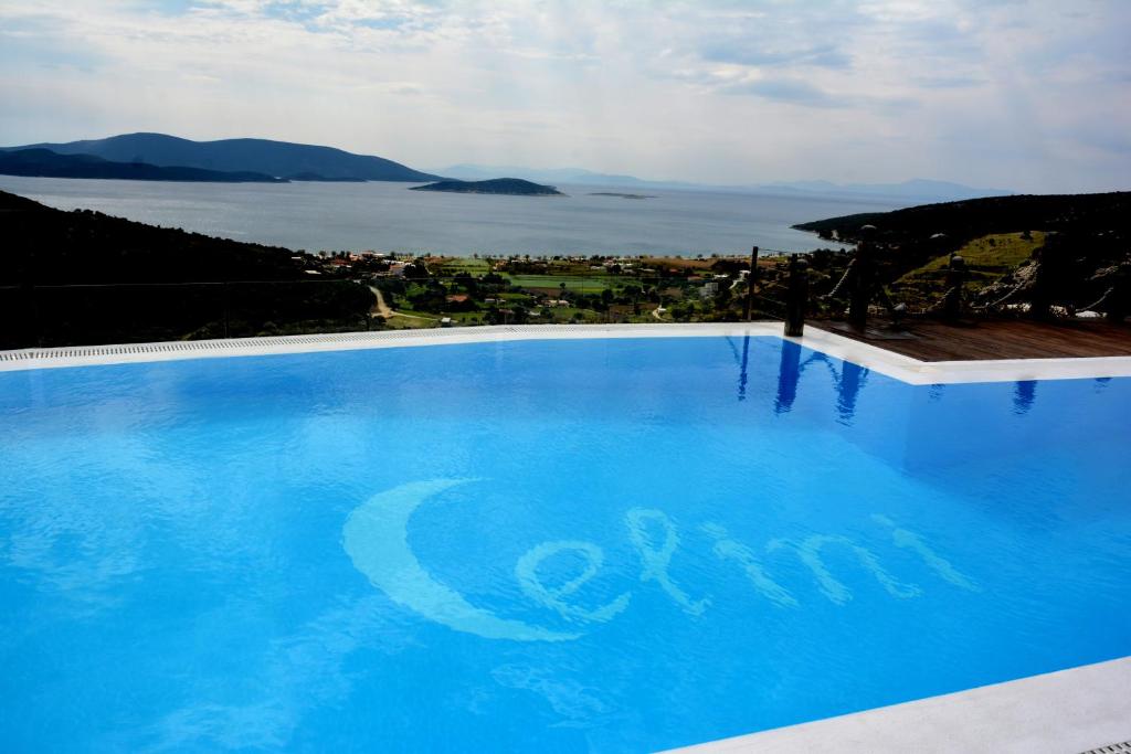 una gran piscina azul con vistas al océano en Celini Suites Hotel, en Marmarion