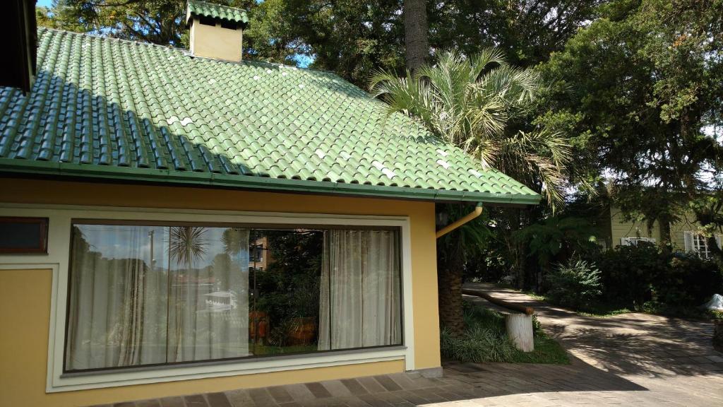 una casa con tetto verde e finestra di Sobrado no Centro de Canela a Canela