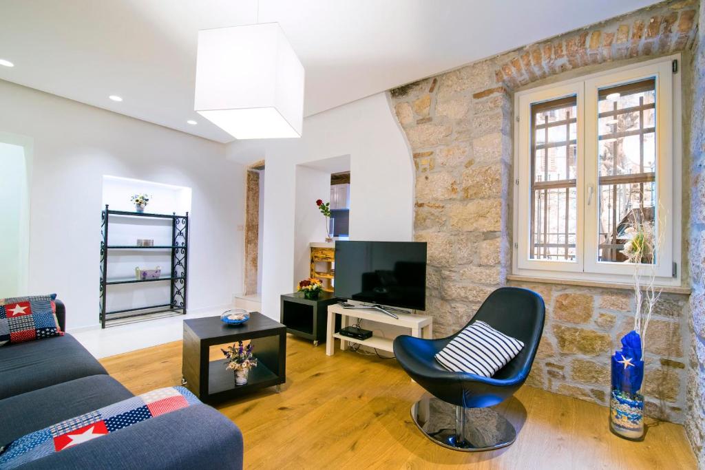 uma sala de estar com um sofá e uma televisão em Apartment Danalu em Rovinj