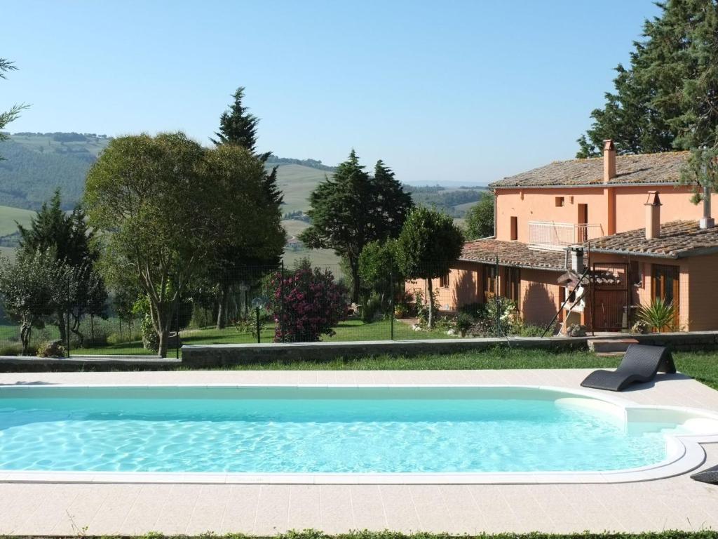 a large swimming pool in front of a house at Belvilla by OYO Sei Orcia in Celle sul Rigo