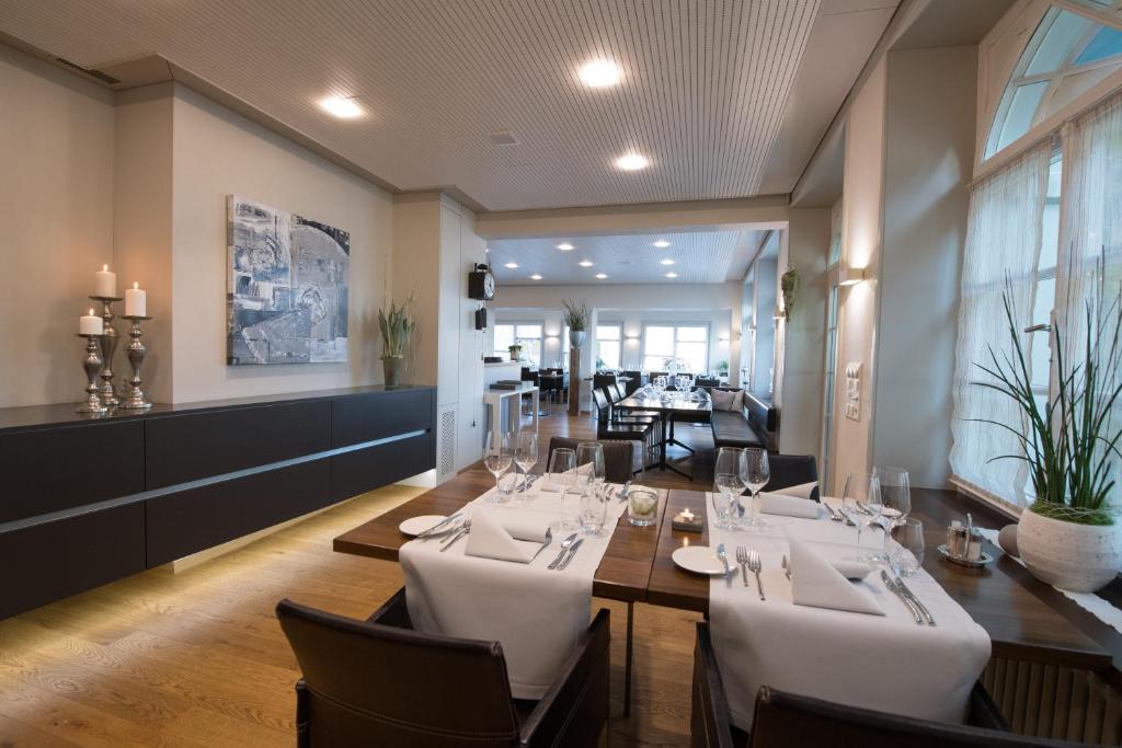 a dining room with a table with white chairs at Gasthaus zum Bahnhof in Berg