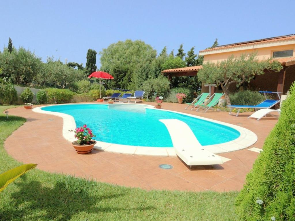 a swimming pool in a yard next to a house at Belvilla by OYO Villa Rita in Buseto Palizzolo