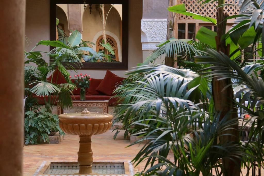 una habitación llena de muchas plantas y una fuente en La Villa Nomade, en Marrakech