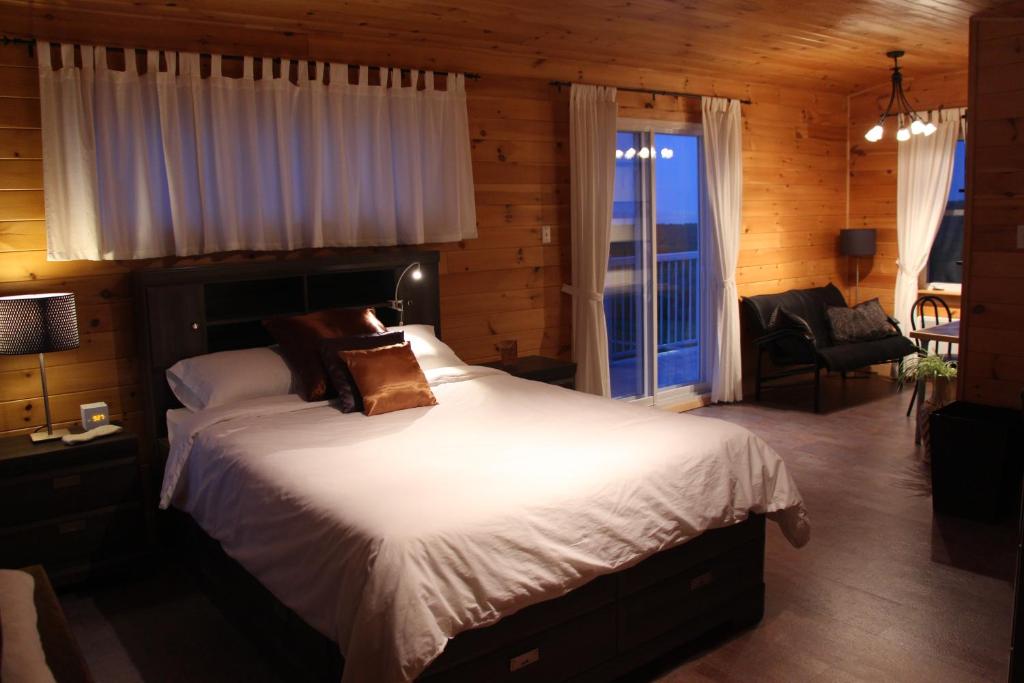 Havre-AubertにあるGîte chez Majoの窓付きの部屋にベッド付きのベッドルーム1室があります。
