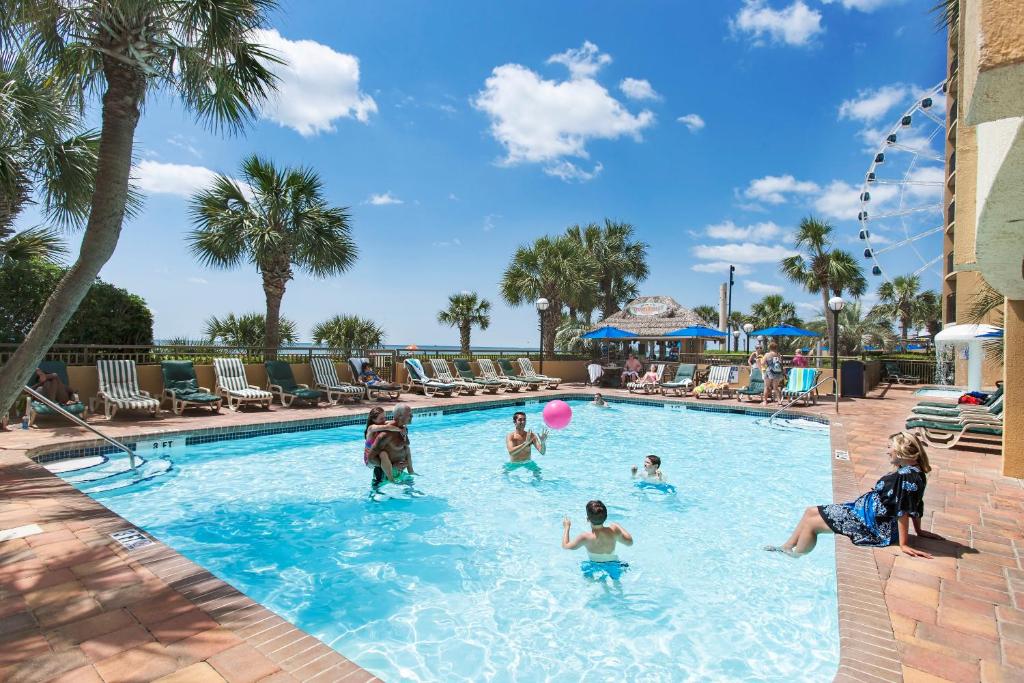 a group of people playing in the swimming pool at a resort at Holiday Pavilion Resort on the Boardwalk in Myrtle Beach