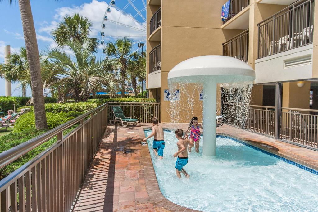 a group of children playing in a pool at a resort at Holiday Pavilion Resort on the Boardwalk in Myrtle Beach